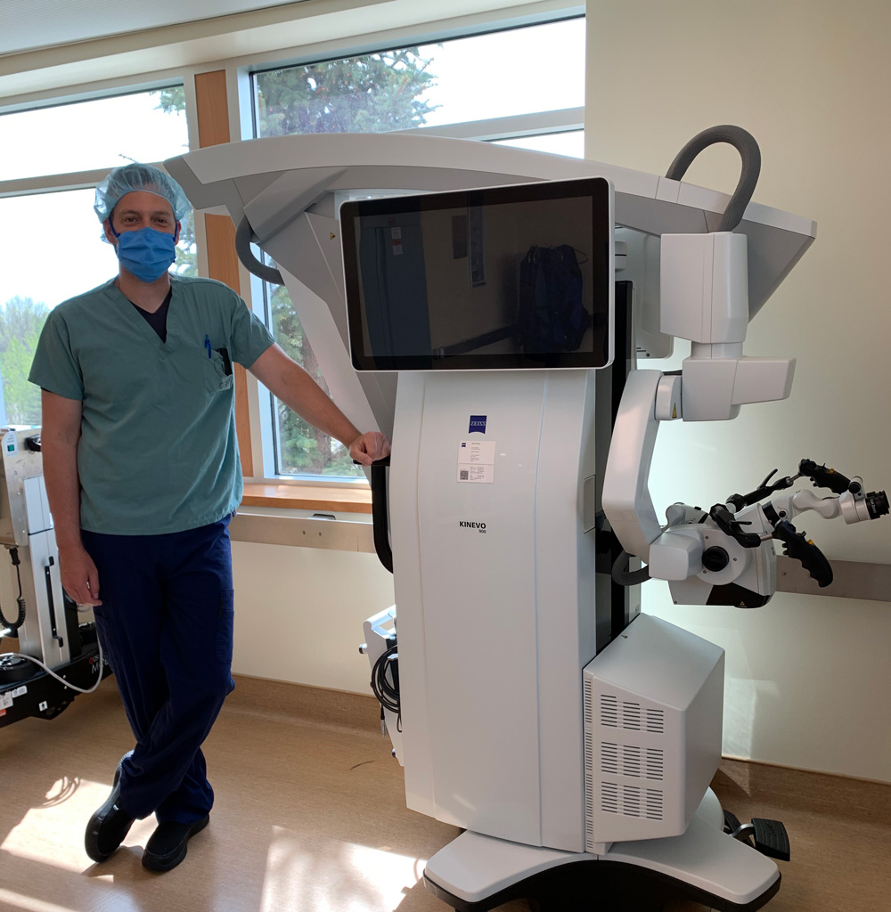 Ryan Kelly stands next to the new neuro microscope.